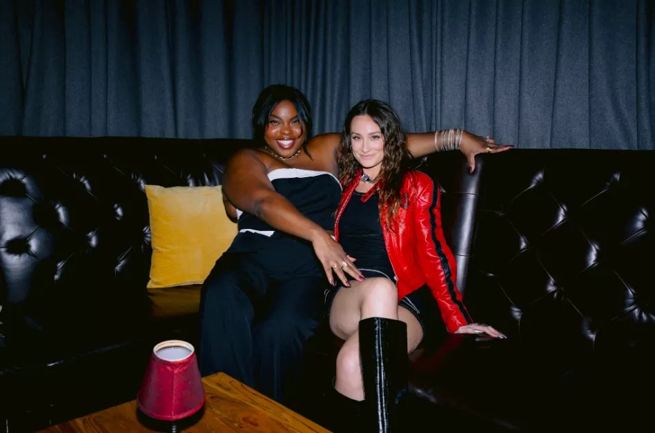 Karolena Theresa and Melissa Rich sitting on a couch