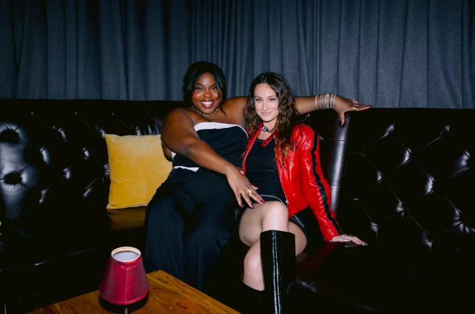 Karolena Theresa and Melissa Rich sitting on a couch