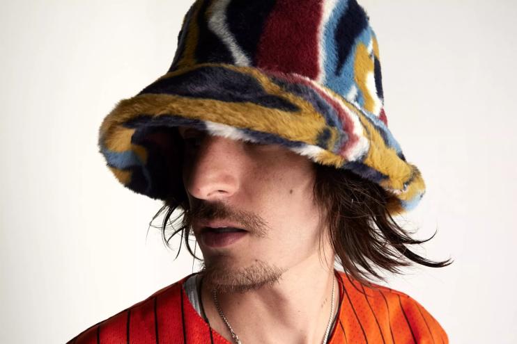 Danny Ocean wearing a bucket hat and orange shirt