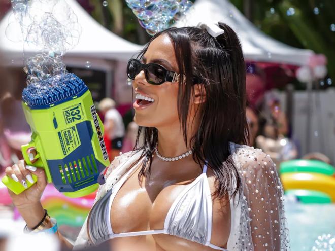 Luna Star holding a bubble gun and wearing a silver bikini