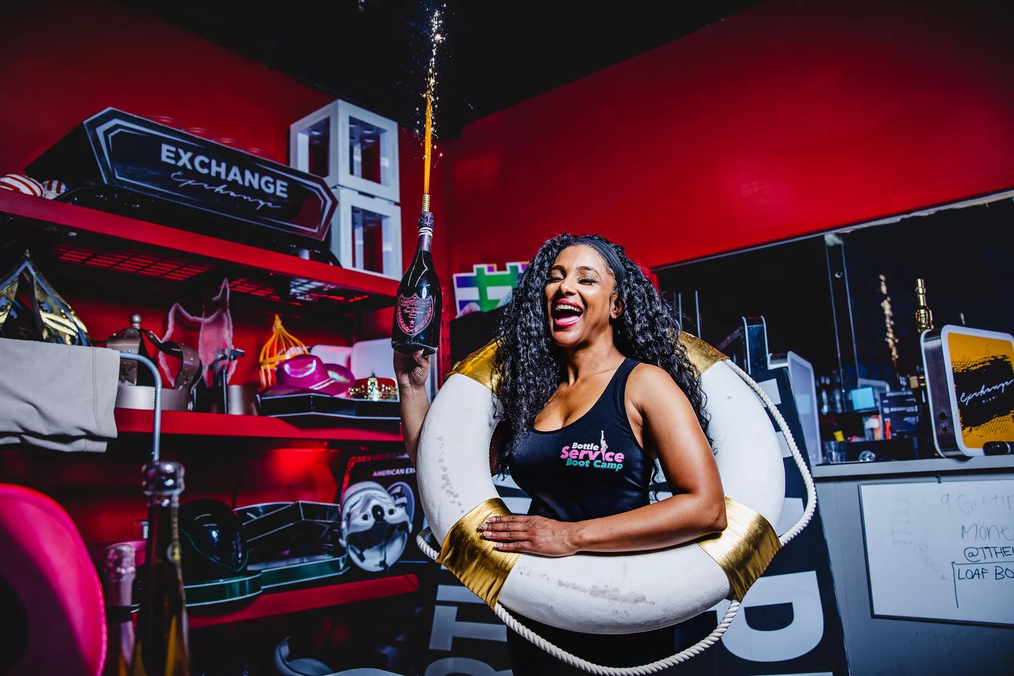 Michelle Kent holding a Champagne bottle and wearing a lifebouy