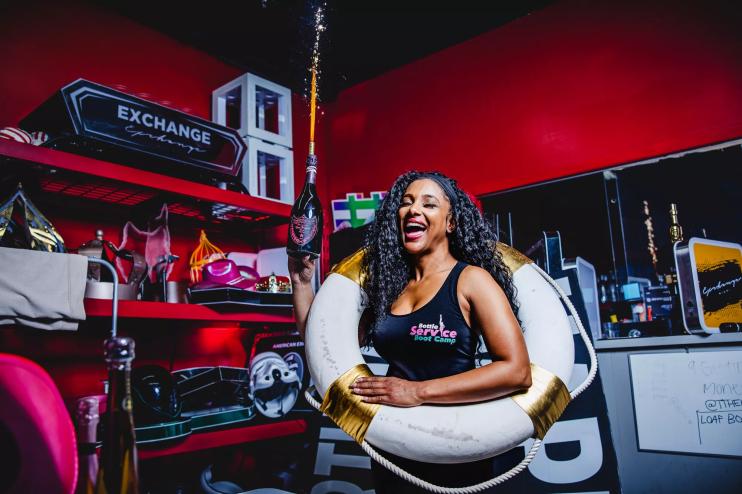 Michelle Kent holding a Champagne bottle and wearing a lifebouy