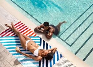A man and woman on the pool deck at Arlo Wynwood