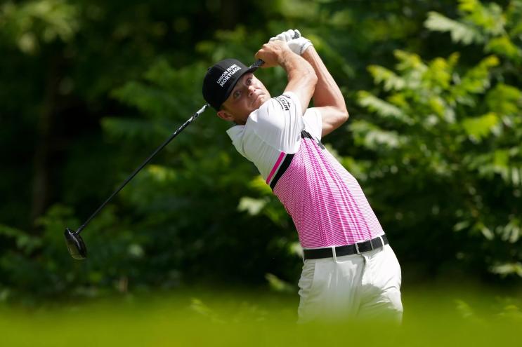 Luke Clanton on the back end of a golf swing, his eyes wide and his face tense