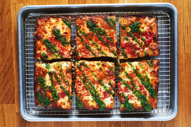 a pizza wiht toppings and green sauce