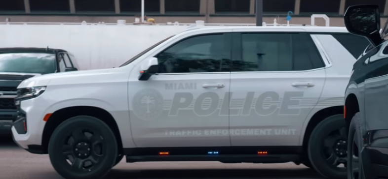 A white police SUV with faded labels to conceal police presence