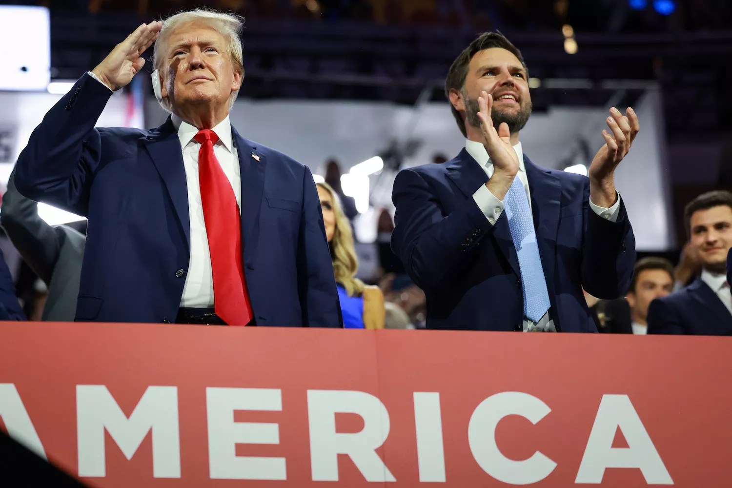 Donald Trump saluting the crowd at the RNC in Milwaukee as J.D. Vance stands beside him applauding