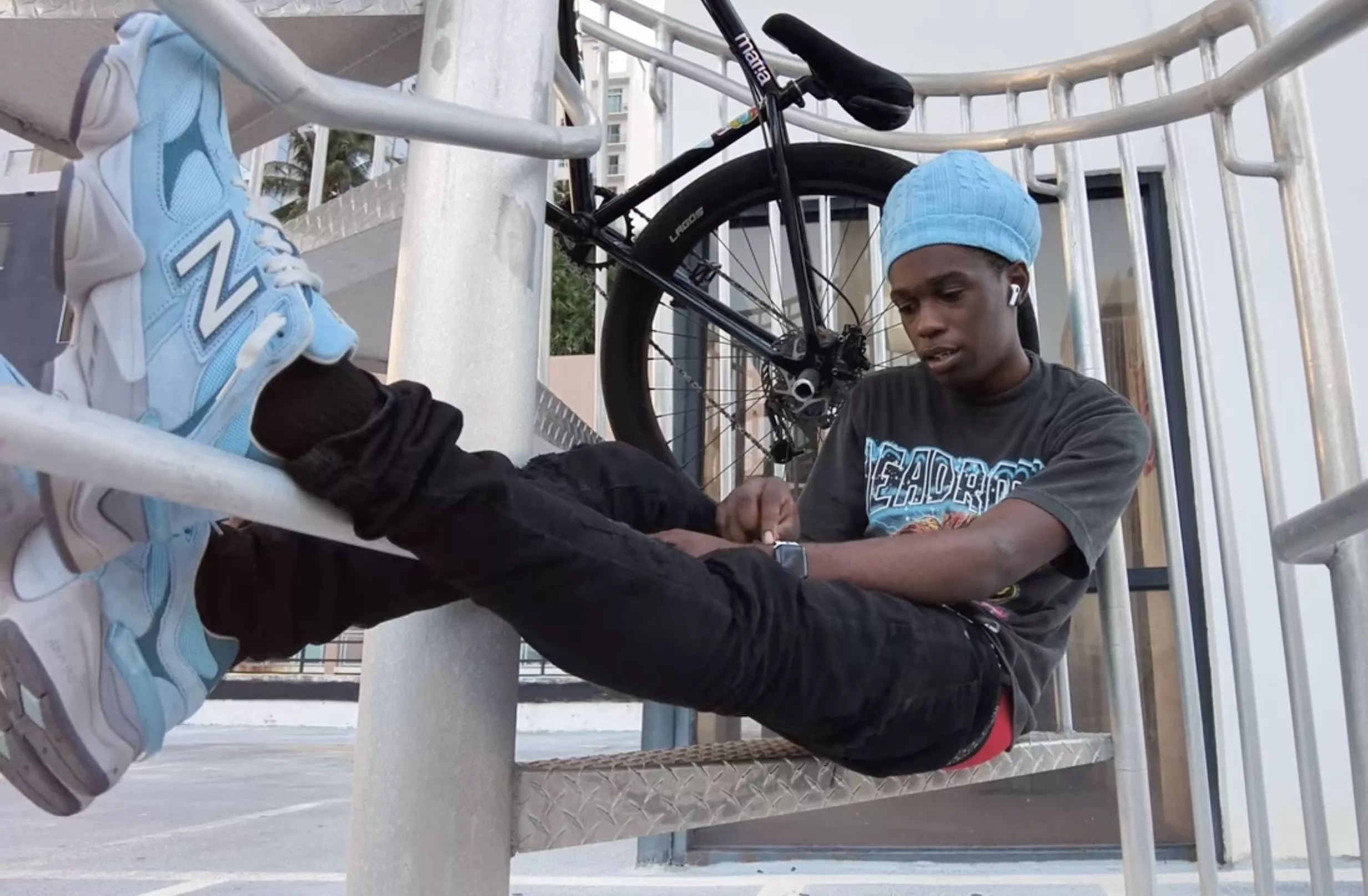 Bicycle stunt rider Frank Sands in repose in Miami, with his bike in the background
