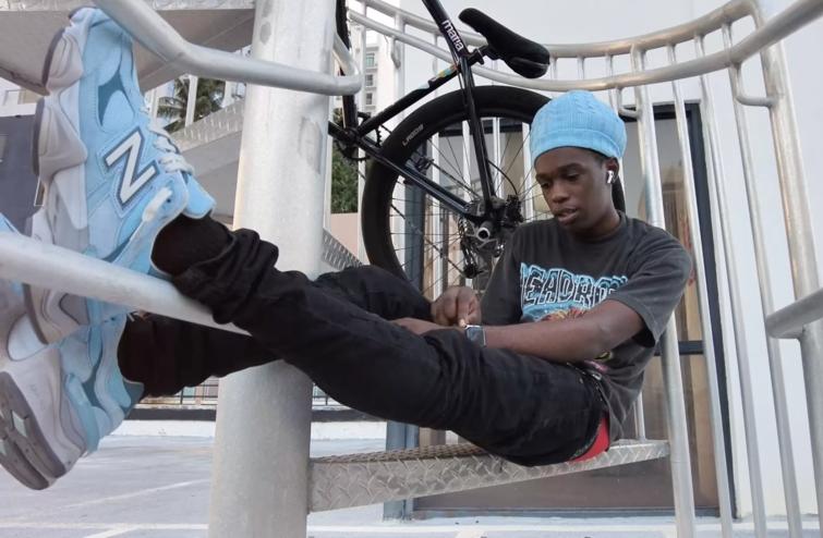 Bicycle stunt rider Frank Sands in repose in Miami, with his bike in the background