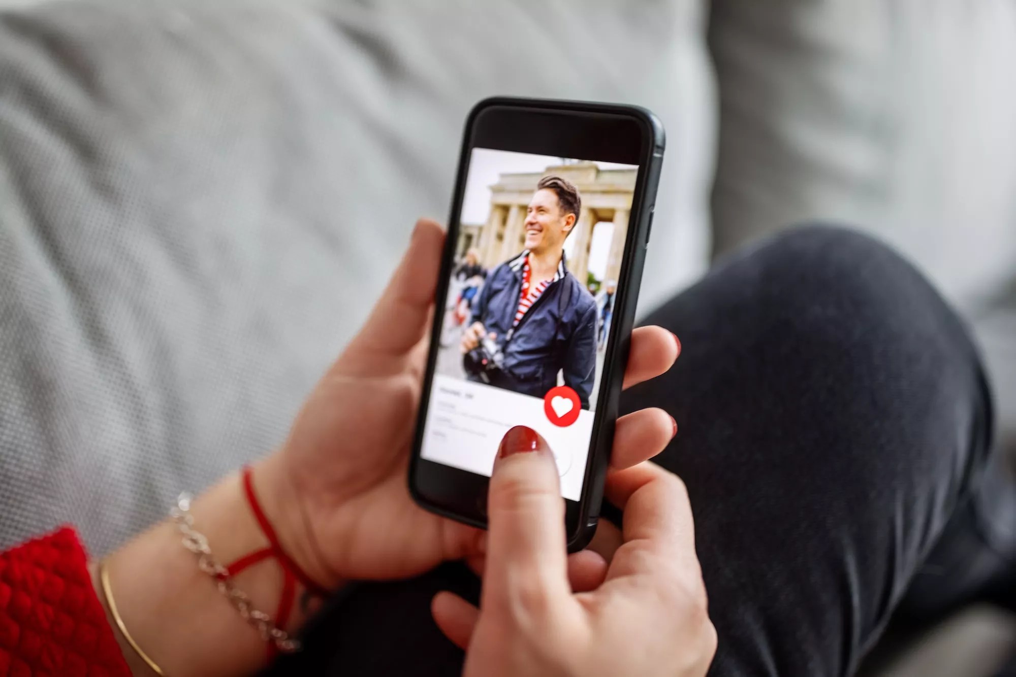 A woman looking at a man's dating profile on her phone