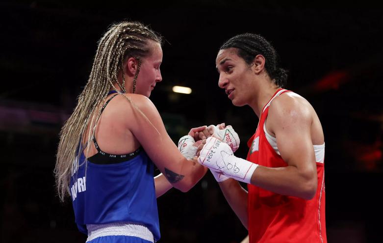 Two Olympic boxers clasp hands in the ring