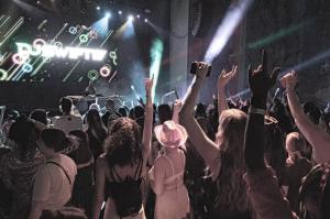 A crowd dancing in front of the stage with DJ Swiftie