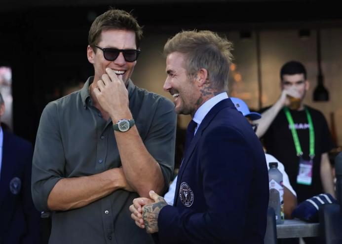 two superstars sharing a moment on the sidelines at a professional soccer game