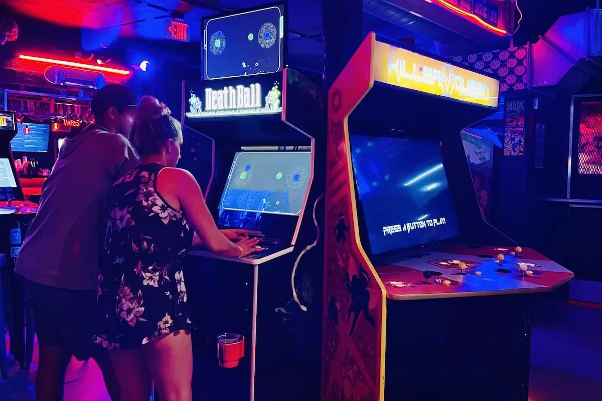 A couple playing an arcade game at Glitch Bar in Fort Lauderdale