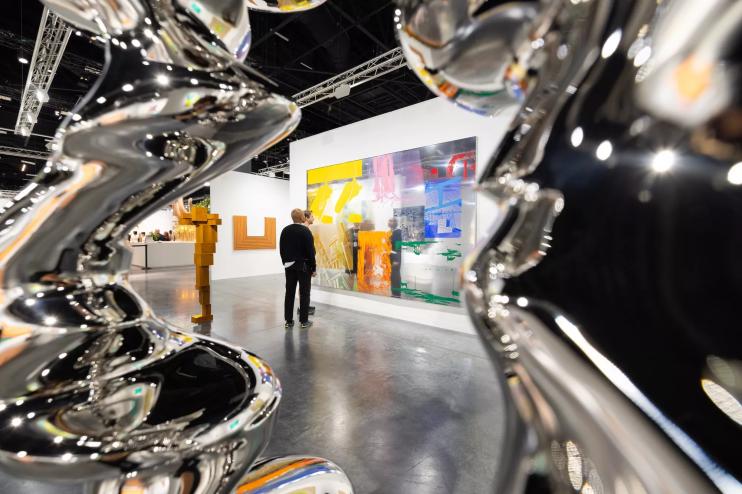 A person looking at the art at Art Basel Miami Beach