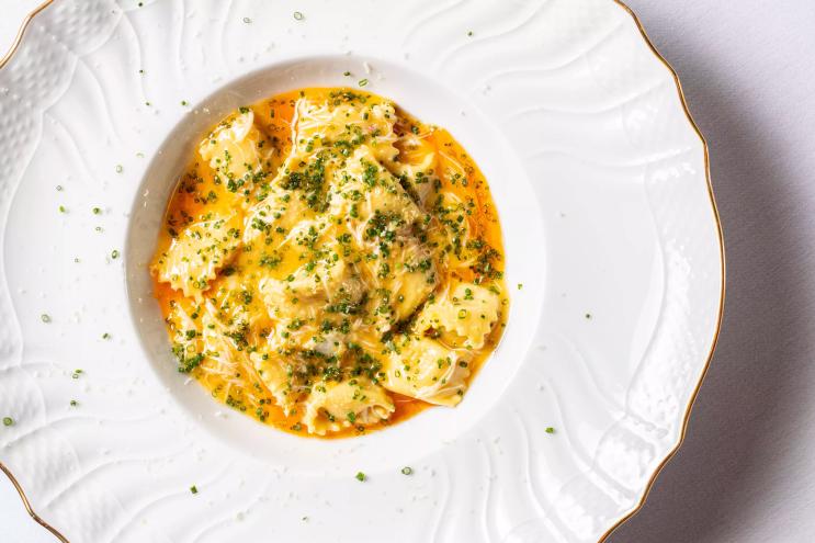 a yellow pasta on a white plate