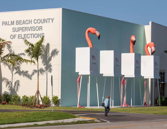 A building labeled "Palm Beach County Supervisor of Elections" with flamingo sculptures at voting booth