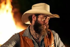 Portrait of Post Malone in a cowboy hat and leather. vest with flames behind him