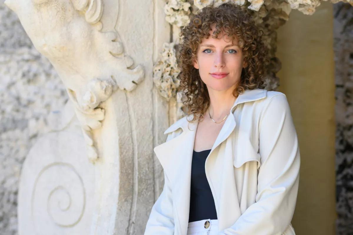 Headshot of artist Lauren Shapiro in front of a wall at Vizcaya Museum & Gardens.
