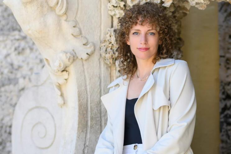 Headshot of artist Lauren Shapiro in front of a wall at Vizcaya Museum & Gardens.