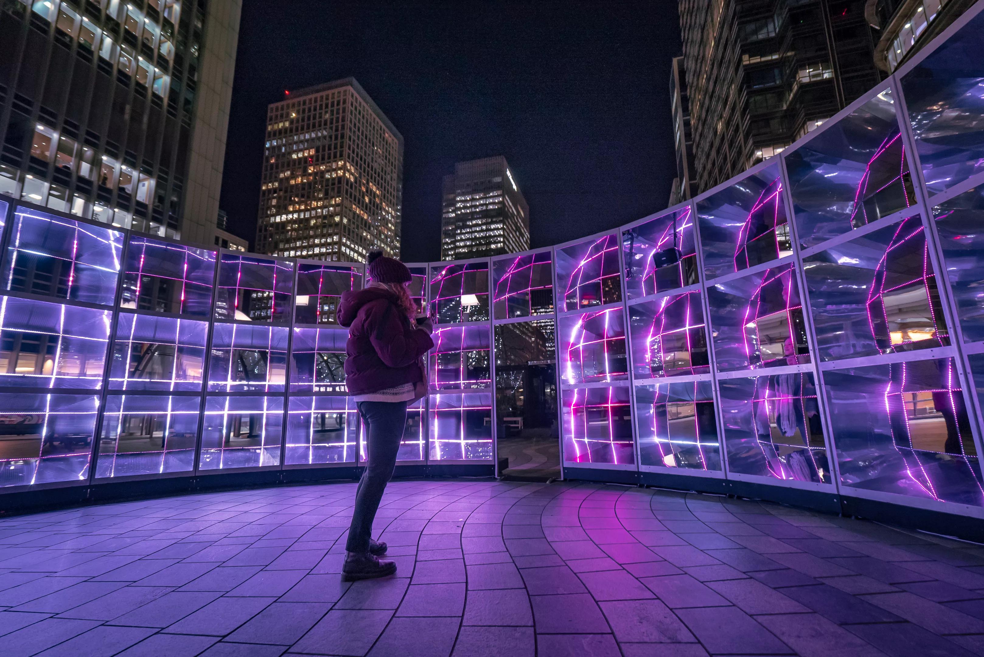 photo of a person standing in front of a walled light installation