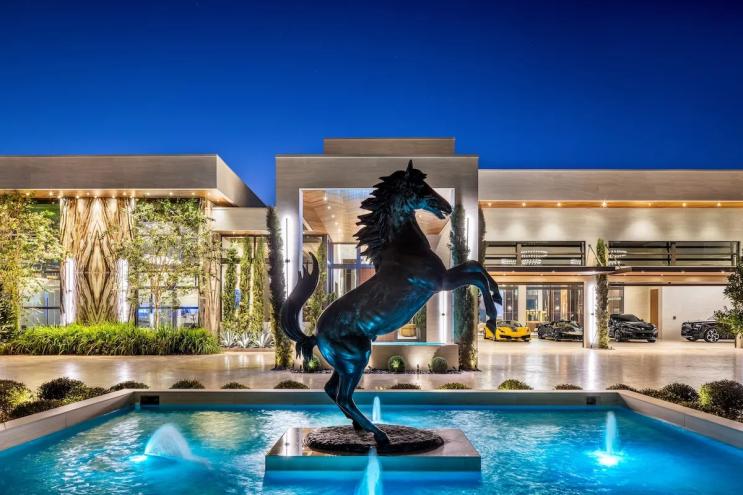 A bronze Ferrari horse at the center of a fountain near the mansion's entrance.