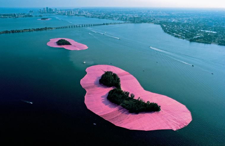 aerial view photo of an island surrounded and outlined with pink cloth in the ocean
