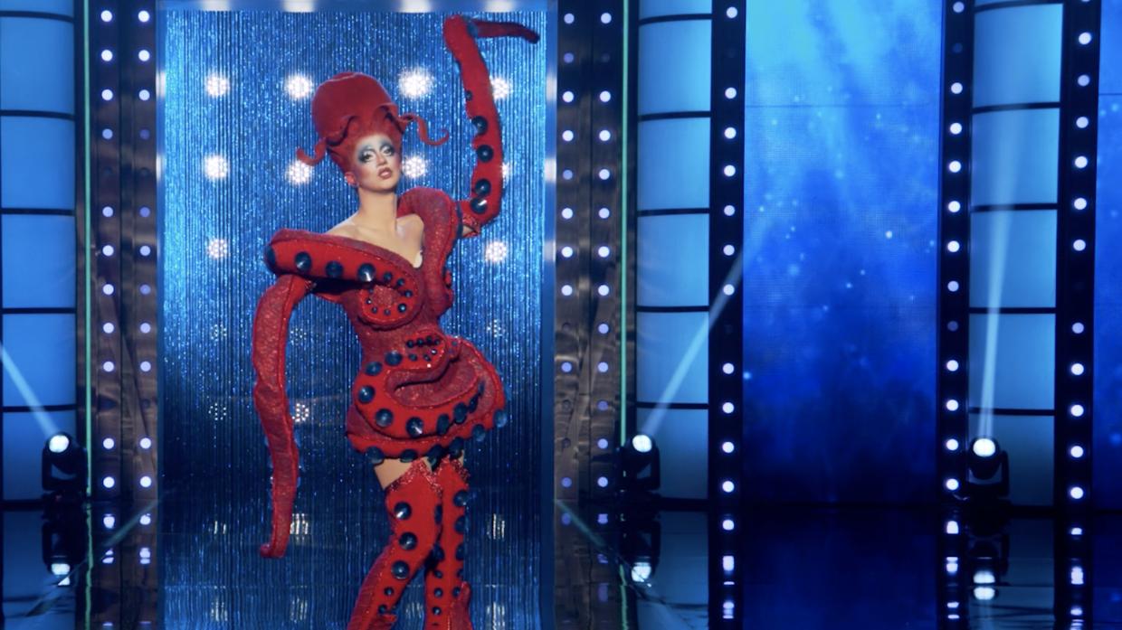 a drag queen walks the runway dressed as a red octopus