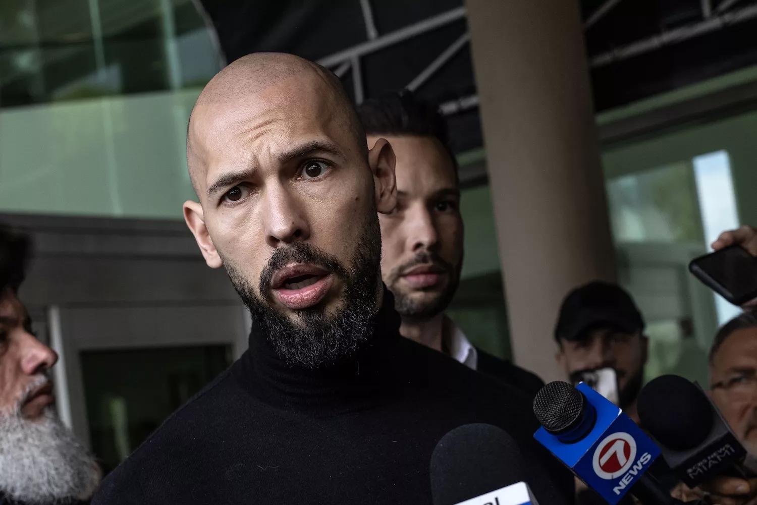 Andrew Tate (L) and Tristan Tate (R) arrive in the United States after a travel ban on them was lifted, at the Fort Lauderdale-Hollywood International Airport on February 27, 2025. The influencer brothers were arrested in late 2022 and charged with human trafficking, alleging that they participated in a criminal ring that lured women to Romania, where they were sexually exploited. Andrew Tate was also accused of rape.