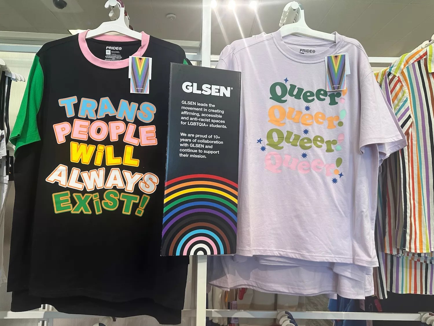 Photo of T-shirts emblazoned with the slogans "Trans People Will Always Exist" and  "Queer Queer Queer Queer! on a Target store rack in Minneapolis in 2023.