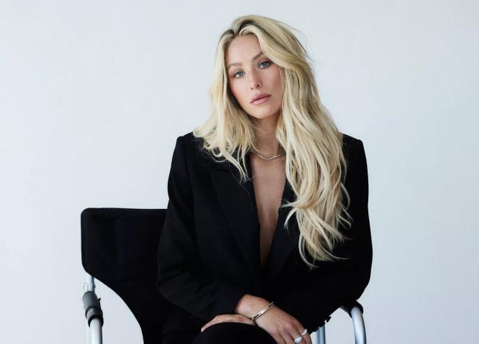 photo of a blonde woman sitting in front of a white backdrop