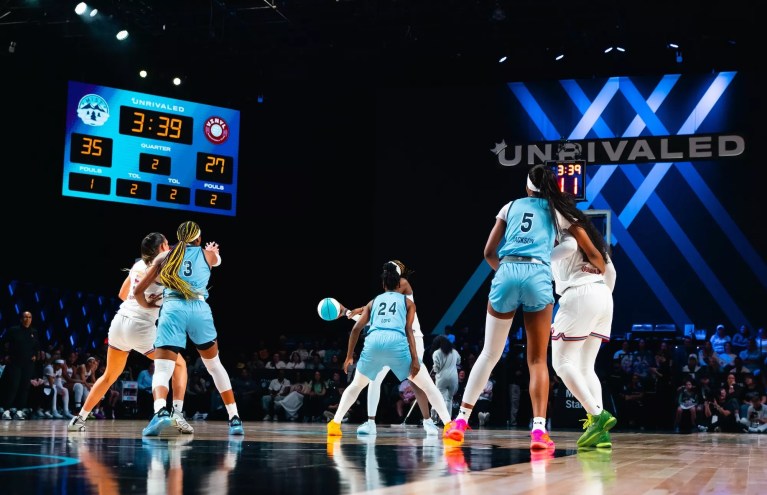 photo of two women's basketball teams playing on a court