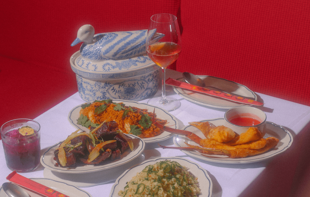 an assortment of Chinese dishes on a white table with a red background