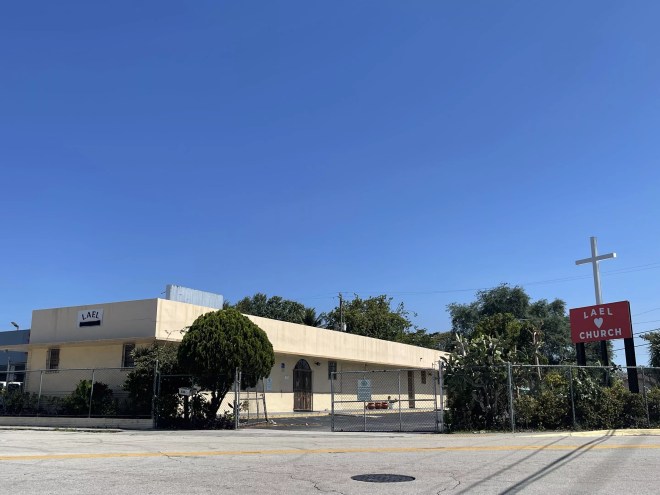 A tan building sits at the corner of SW 13th Street and SW 4th Avenue.