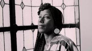 a sepia-toned headshot of poet Aja Monet