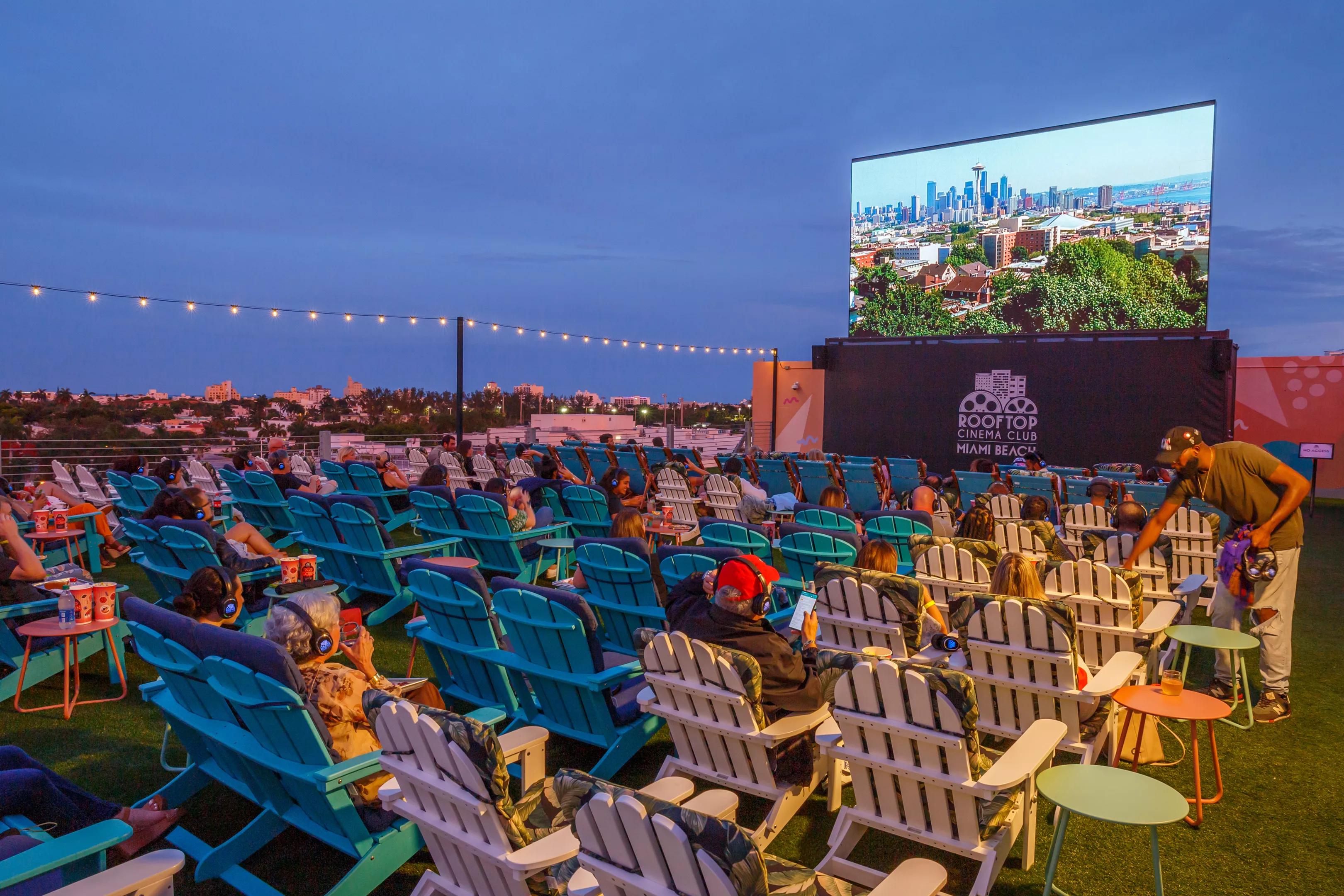 photo of Adirondack chairs in front of a movie screen on a rooftop