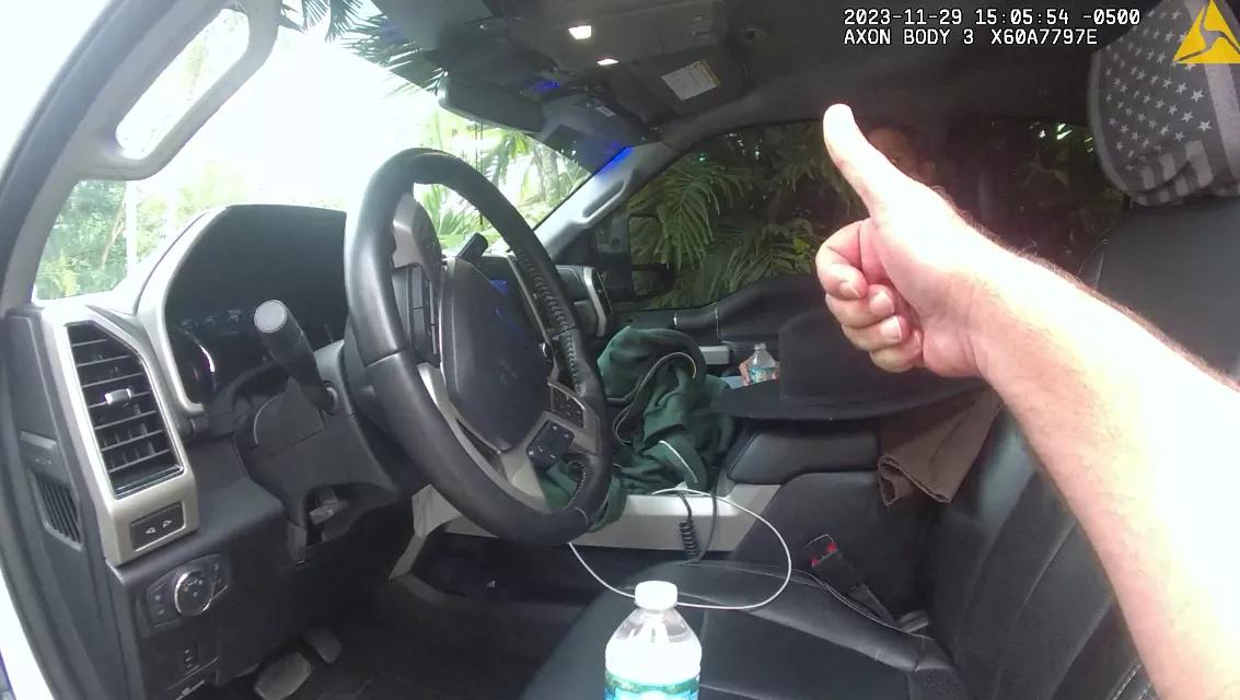 Miami-Dade Police officer gives a thumbs up to one of the officers as he sits in the truck.