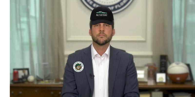 Florida Attorney General James Uthmeier wearing an alligator alcatraz hat and an alligator alcatraz button