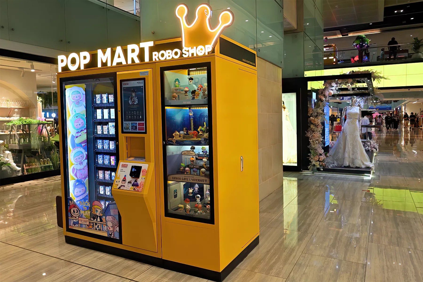 a yellow Pop Mart vending machine inside a mall