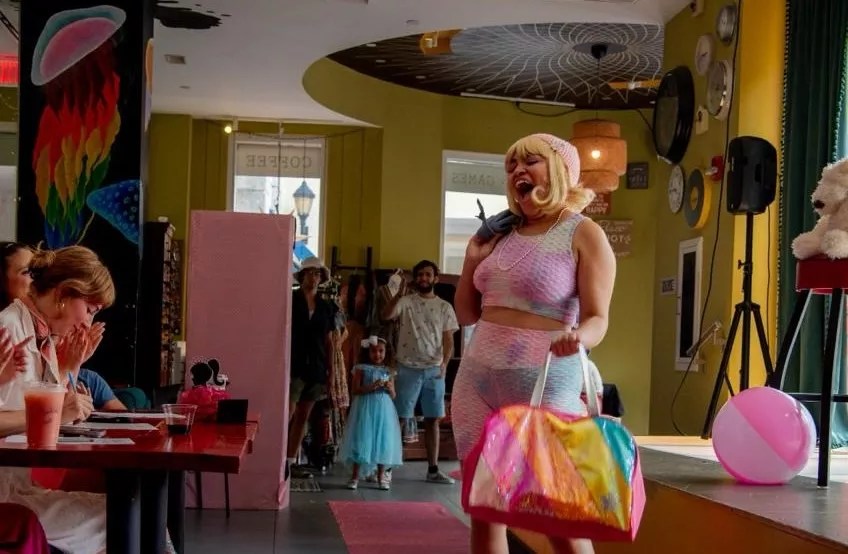 A woman performs in front of judges at a Barbie-themed fashion show