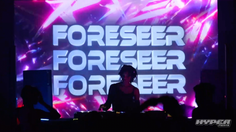 DJ is playing in front of an LED screen.