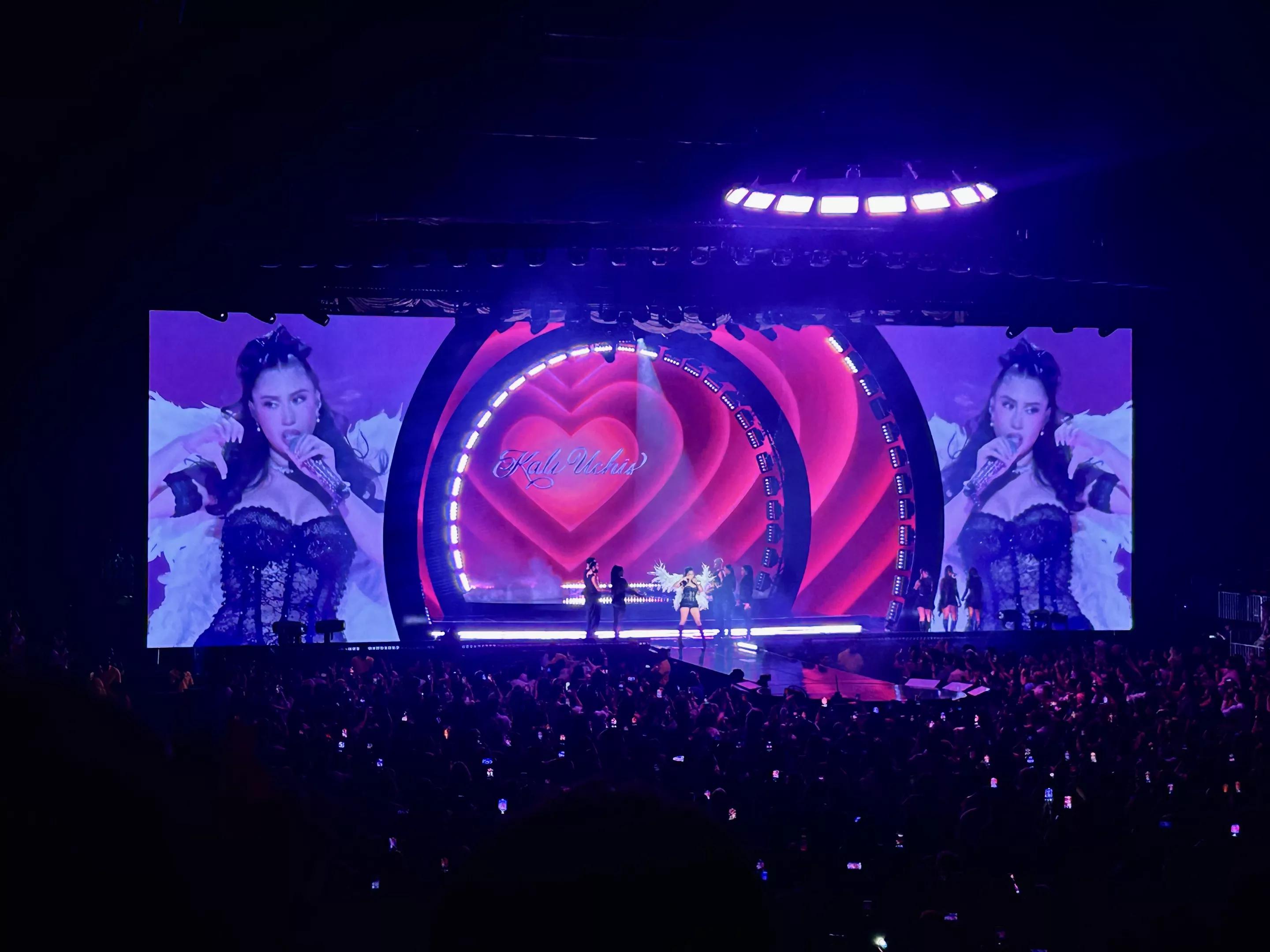 Picture of Kali Uchis singing on stage in front of a screen projecting a heart.