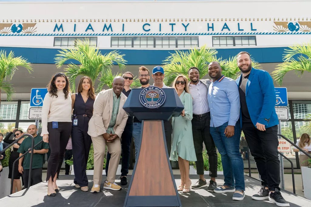 Mayor Francis Suarez stands at the podium outside Miami City Hall with Elian Asparouhov of Founders Fund, Keith Rabois from Khosla Ventures, Jack Abraham of Atomic, Erick Gavin of Venture Miami, Ja'dan Johnson from Miami Hack Week, Maria Derchi Russo of Refresh Miami, and Avery Akkineni from VaynerX.