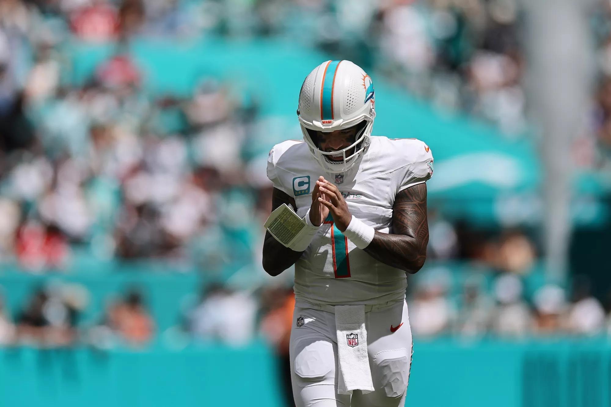 Miami Dolphins quarterback Tua Tagovaiola strikes a prayer-like pose after his team scored a touchdown during the first half against the New England Patriots at Hard Rock Stadium in Miami Gardens on September 14, 2025.